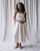 Woman in a white dress against a white curtain background
