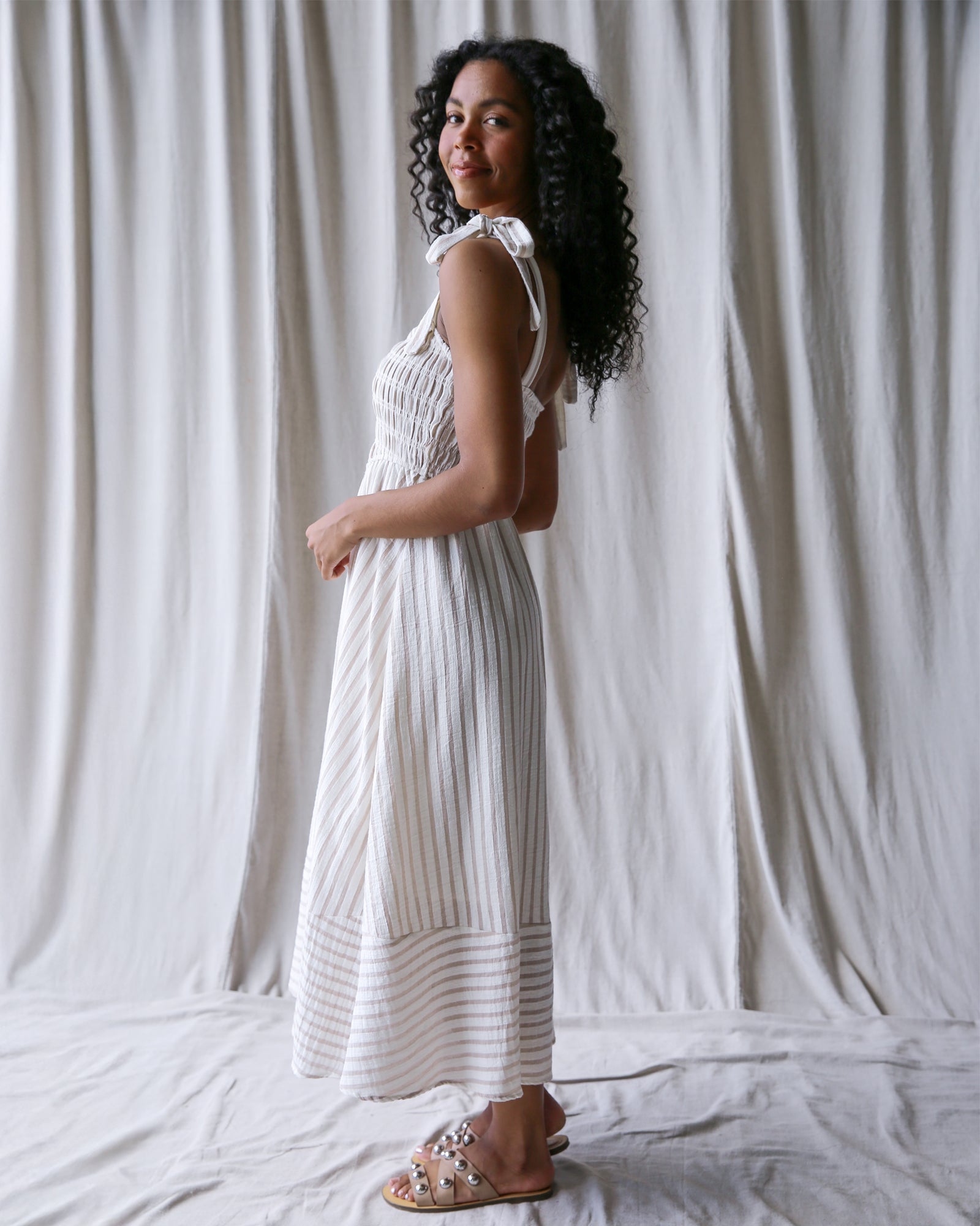 Woman wearing a white dress standing against a plain white background