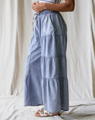 Blue tiered skirt worn by a person on a neutral background
