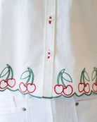 White shirt with cherry embroidery on a white background