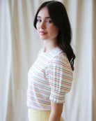 Woman wearing a striped shirt against a plain background