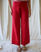 Person wearing red wide-leg pants and a striped top against a white background