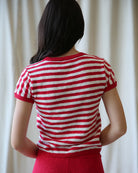 Person wearing a red and white striped shirt against a plain background