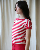Woman wearing a red and white striped sweater against a plain background