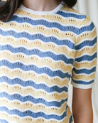 Close-up of a person wearing a blue and yellow striped sweater.