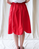 Red skirt worn by a person on a white background