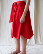 Red skirt with white trim worn by a person on a plain background