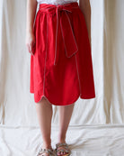 Red skirt with white trim worn by a person on a white background