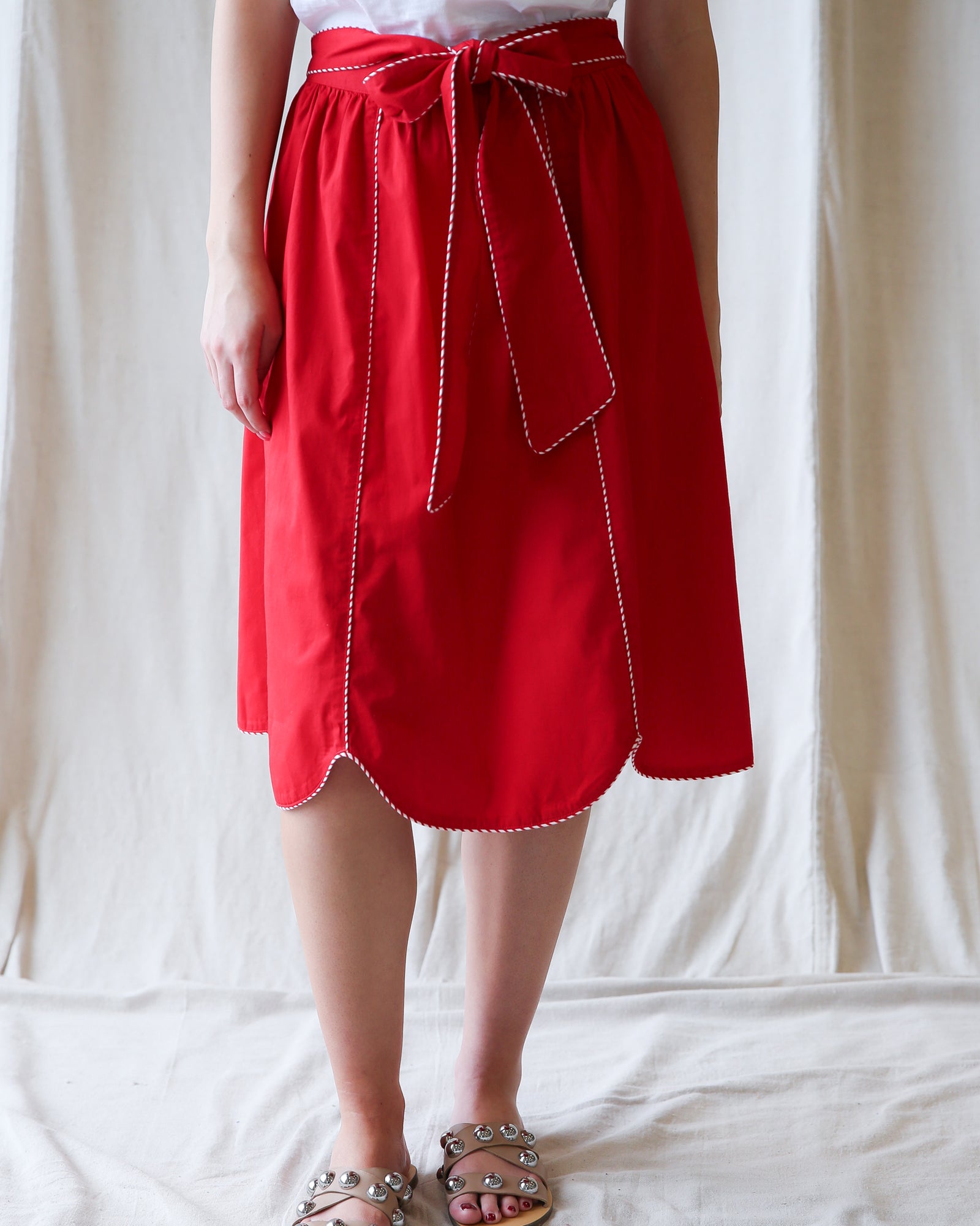 Red skirt with white trim worn by a person on a white background