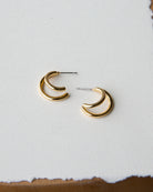 Gold hoop earrings on a light gray background