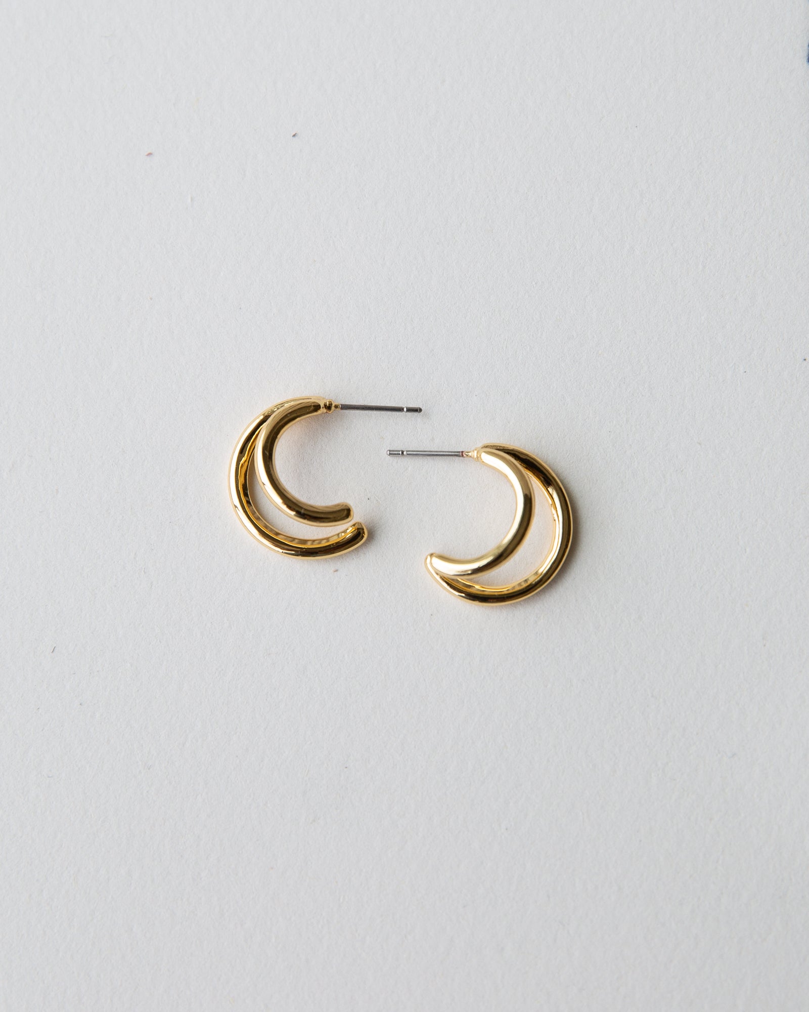 Gold hoop earrings on a light gray background