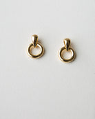 Gold hoop earrings on a light gray background