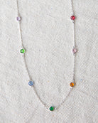 Necklace with colorful gemstones on a textured white background