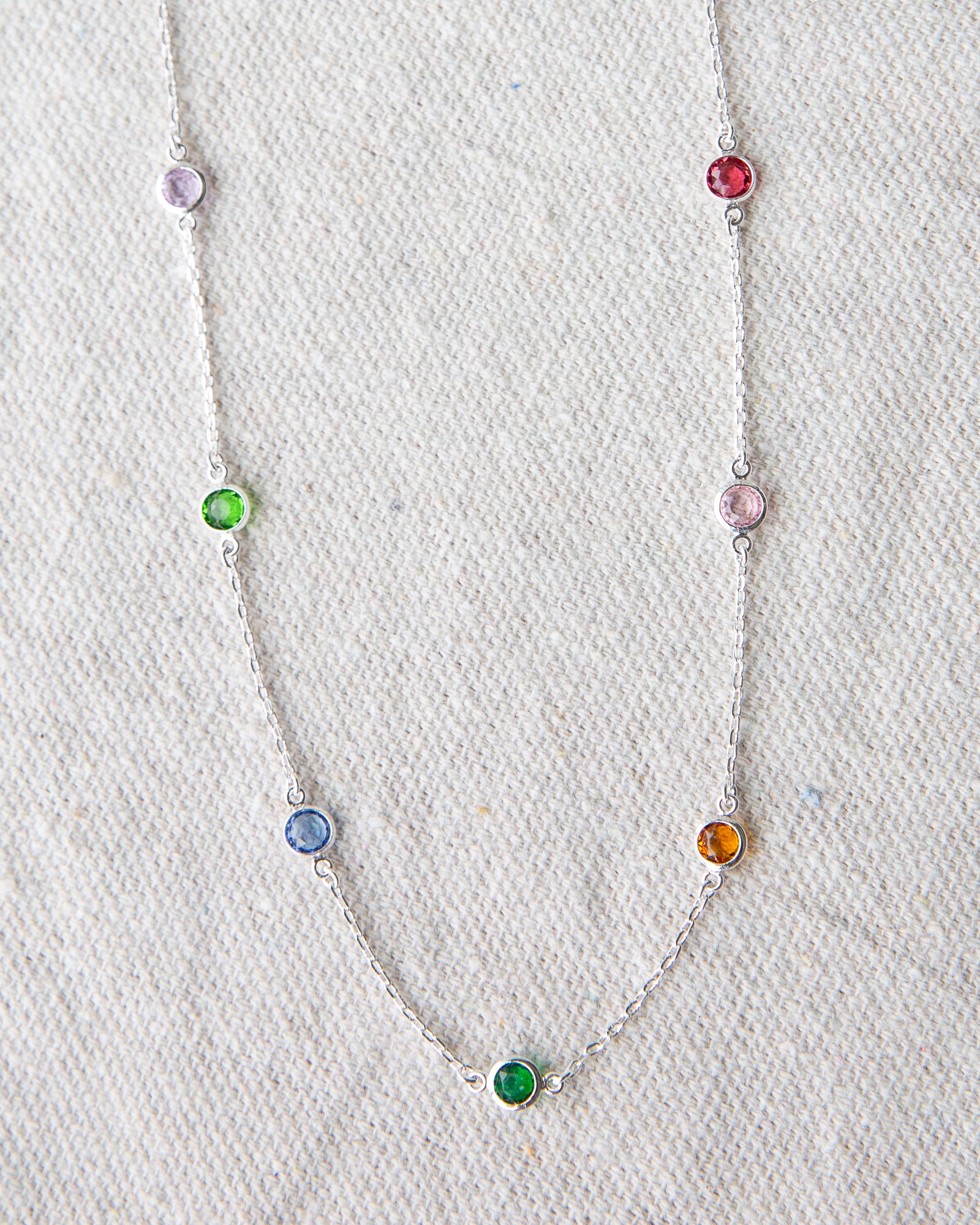 Necklace with colorful gemstones on a textured white background
