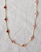 Necklace with pink flower-shaped pendants on a light gray background