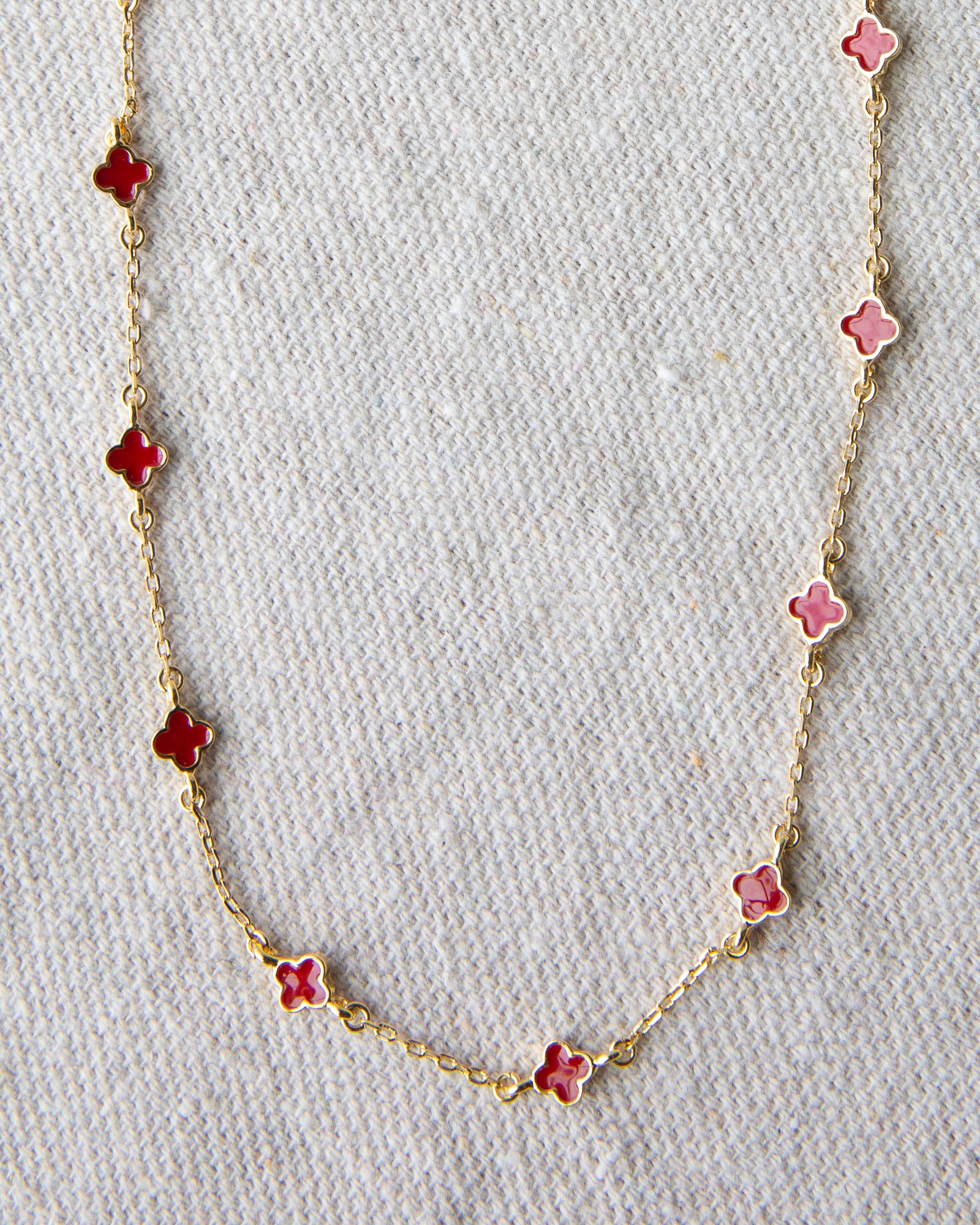 Necklace with pink flower-shaped pendants on a light gray background