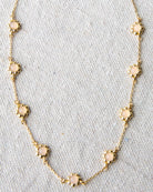 Gold necklace with pink opal stones on a light gray background