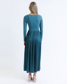 Woman wearing a teal long-sleeve dress on a white background