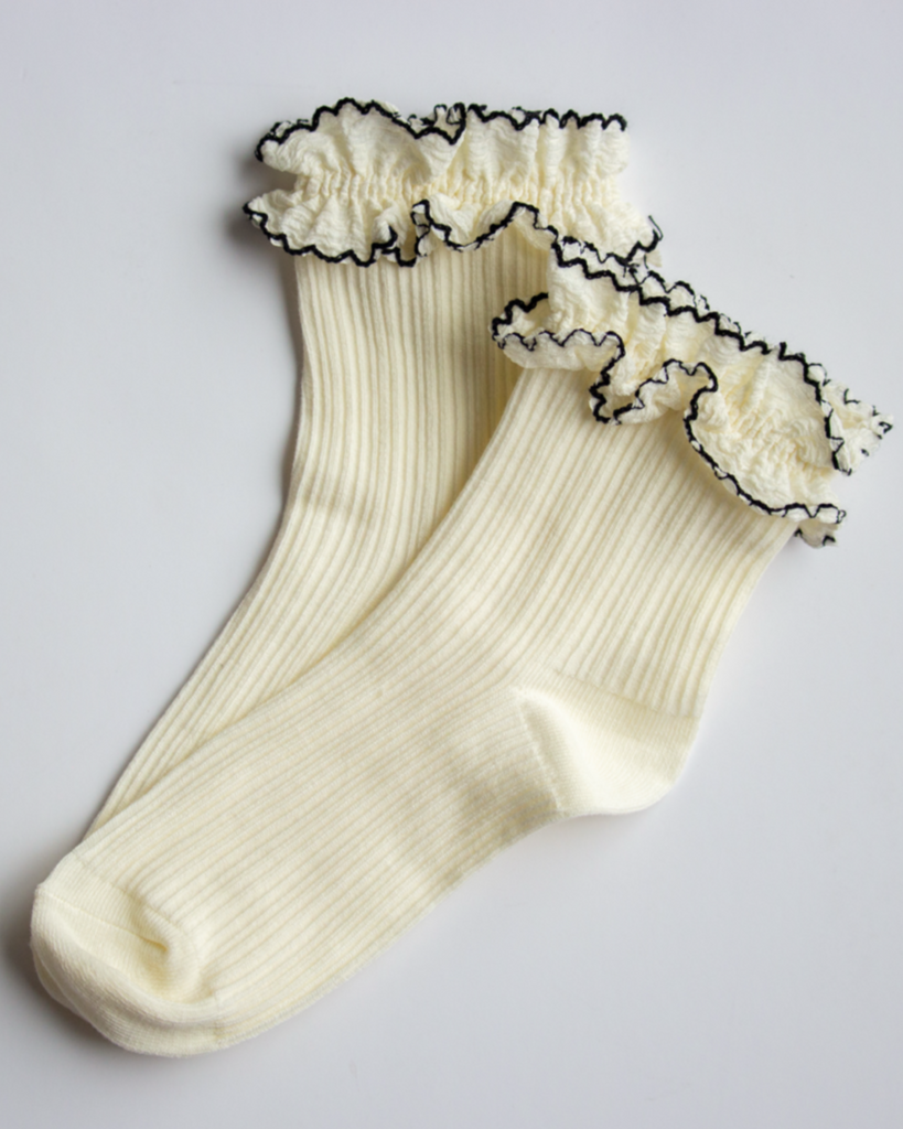 White socks with black lace trim on a light gray background