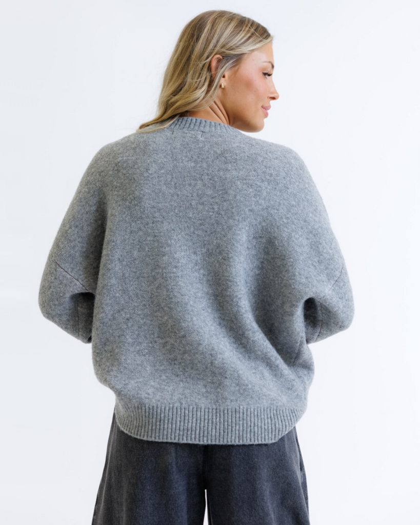 Woman wearing a gray sweater on a white background