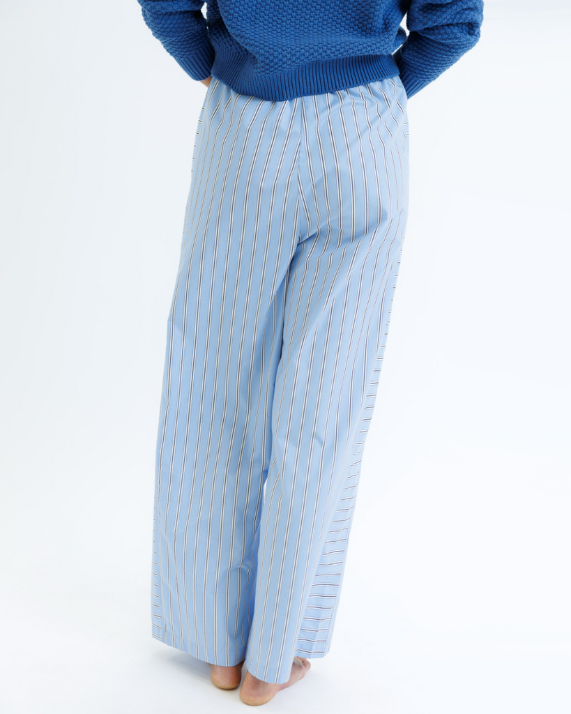 Light blue striped pants worn by a woman on a white background