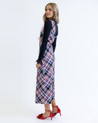 Woman wearing a plaid dress over a black top on a white background