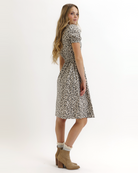 Woman wearing an animal print dress on a white background