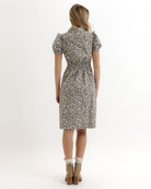 Woman wearing an animal print dress on a white background