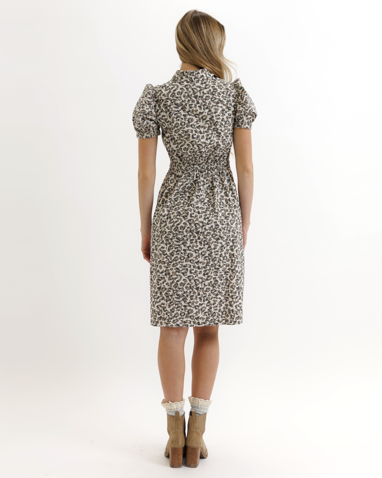 Woman wearing an animal print dress on a white background