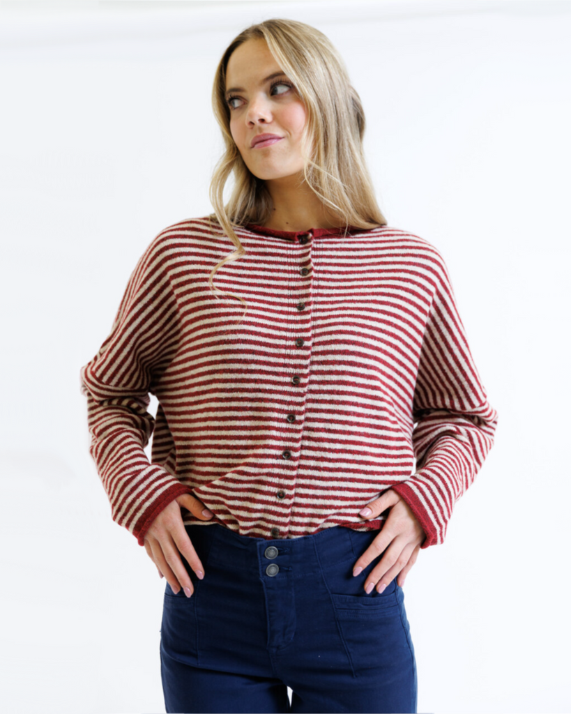 Woman wearing a red and white striped shirt with blue pants on a white background