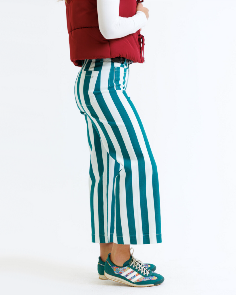 Woman wearing green and white striped pants on a white background