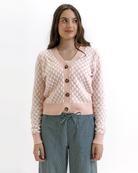 Woman wearing a pink checkered cardigan with buttons on a white background