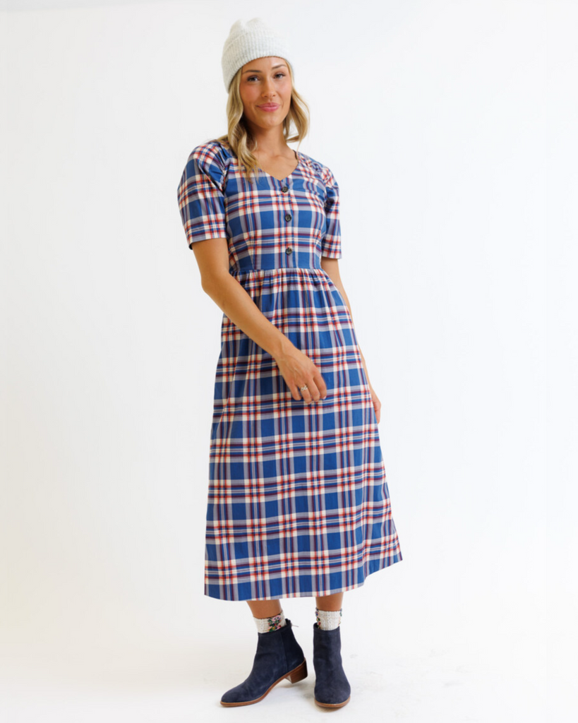 Woman wearing a blue and red plaid dress on a white background