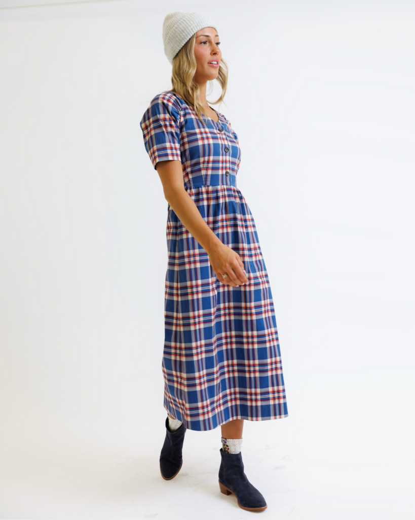 Woman wearing a blue and red plaid dress on a white background