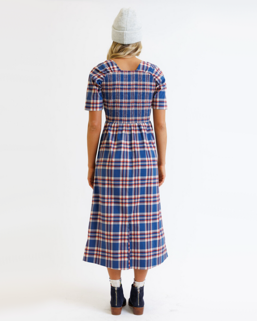 Woman wearing a blue and red plaid dress on a white background