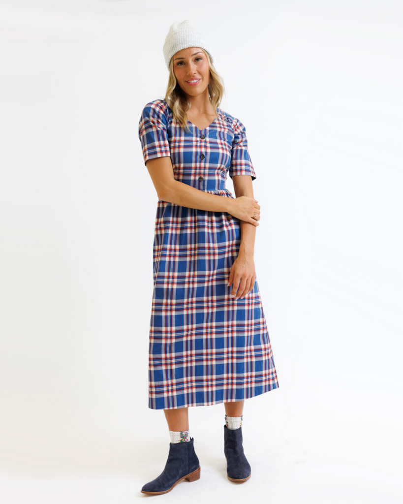 Woman wearing a blue and red plaid dress on a white background