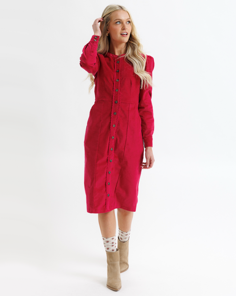 Woman wearing a red dress with buttons on a white background
