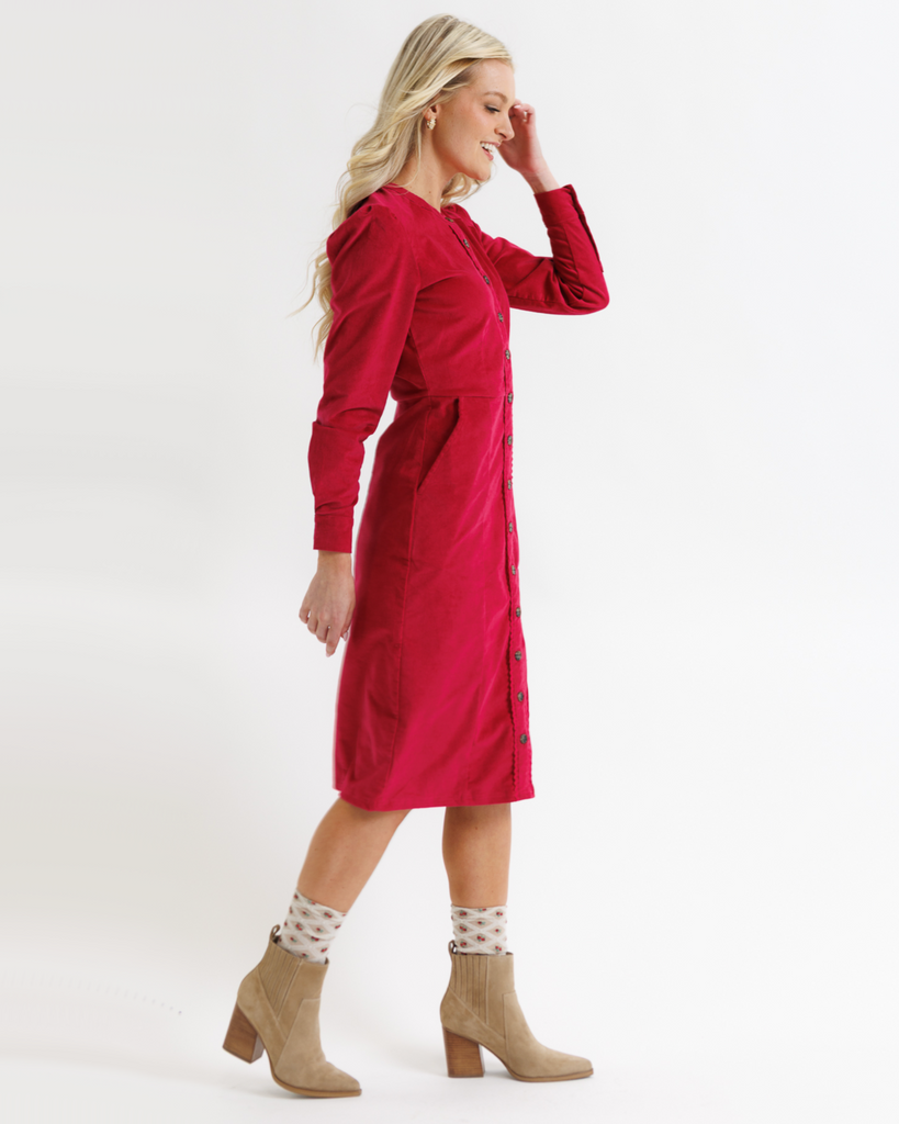 Woman wearing a red dress with long sleeves on a white background