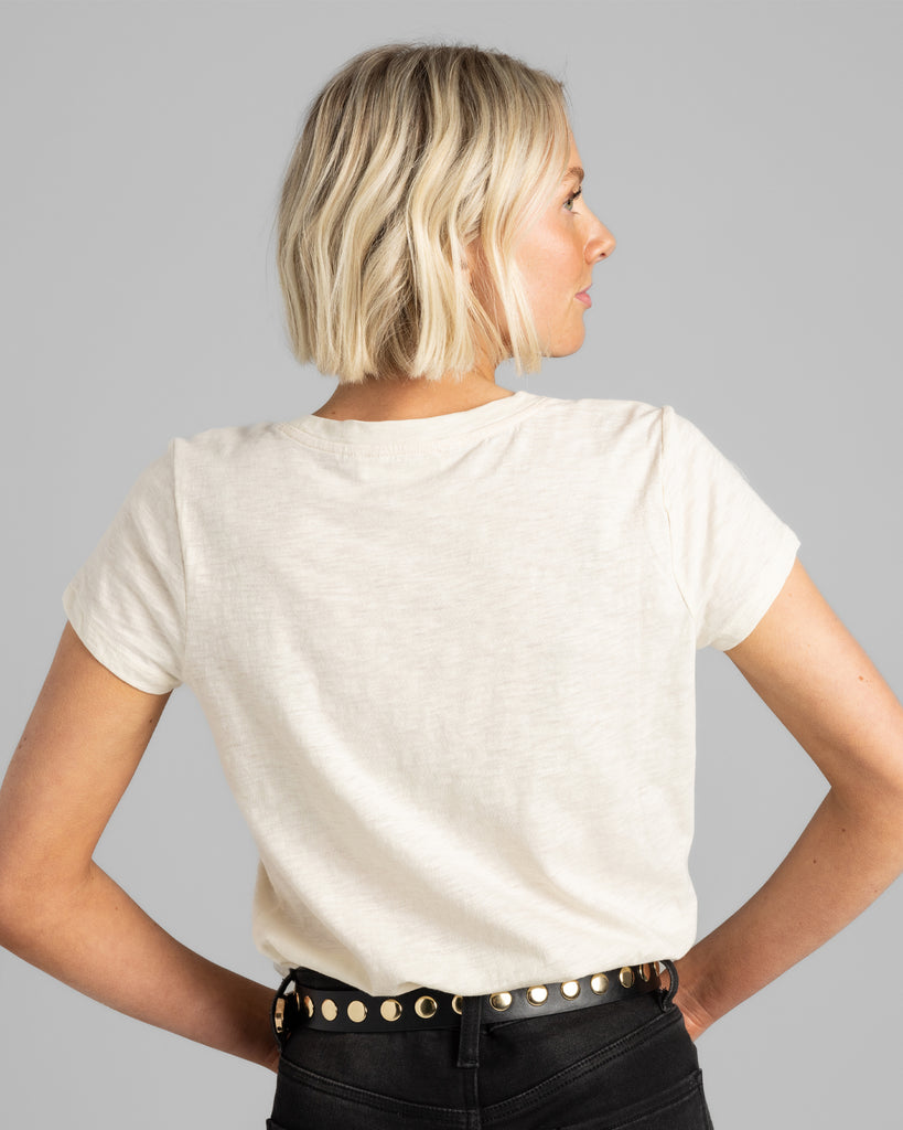 Back view of model wearing a cream colored short sleeve t-shirt