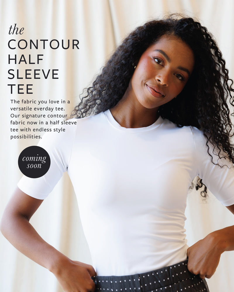 Woman wearing a white contour half sleeve tee with text about the fabric and style.