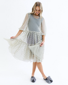 Woman wearing a polka dot dress on a white background