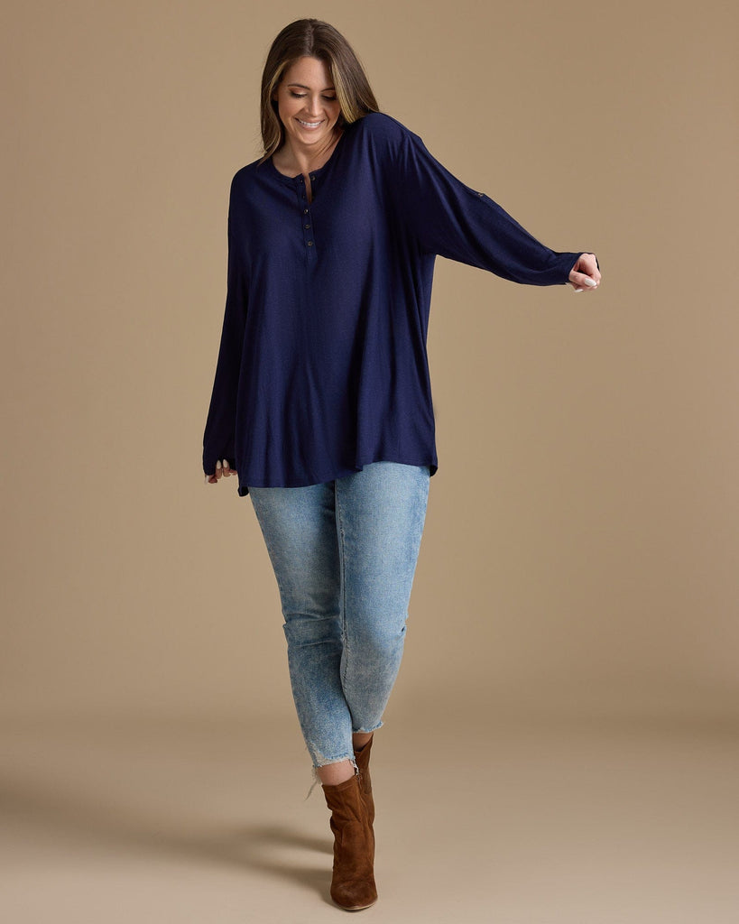 Woman in a navy, long sleeve, oversized, loose fitting blouse