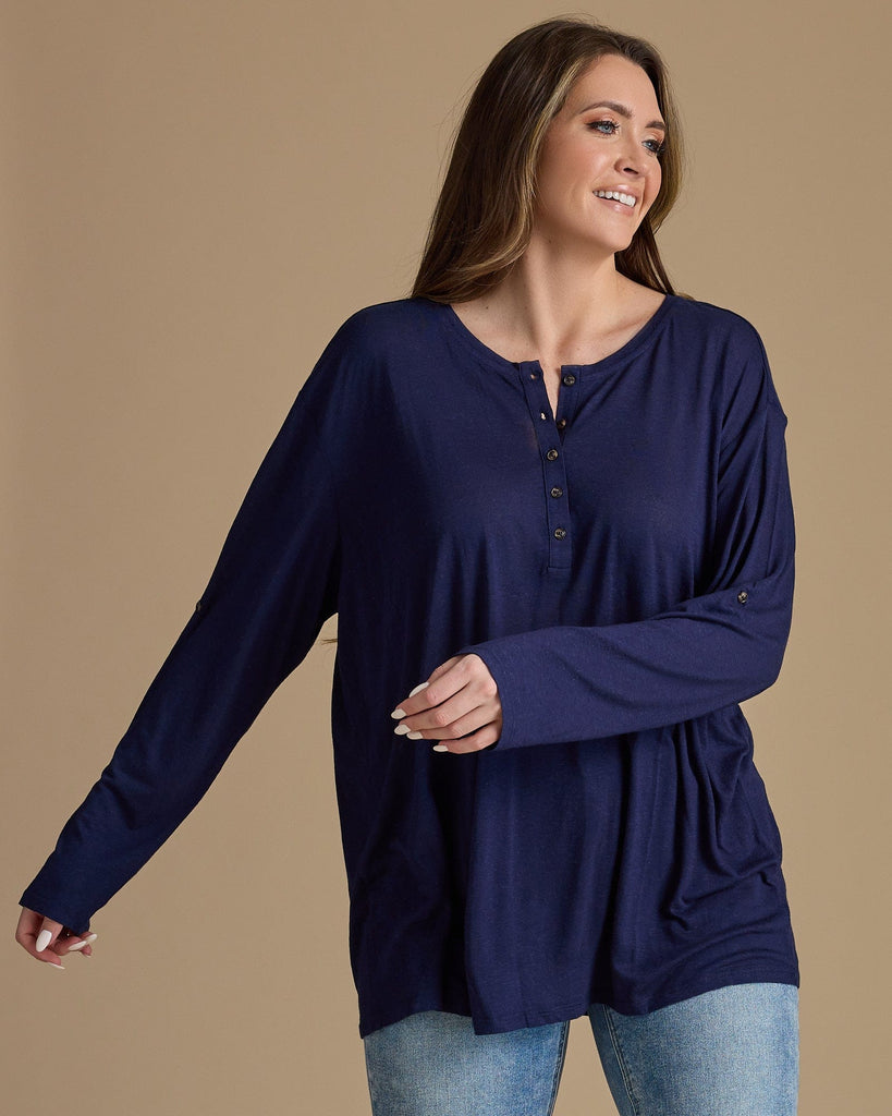 Woman in a navy, long sleeve, oversized, loose fitting blouse