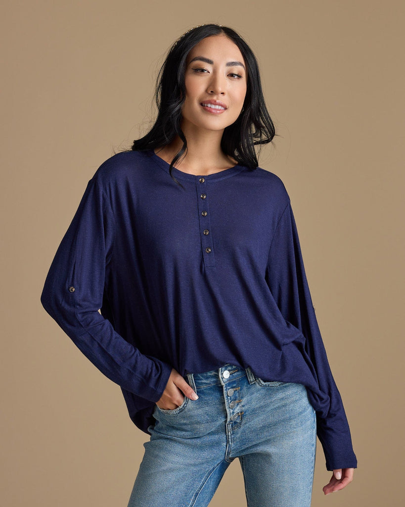 Woman in a navy, long sleeve, oversized, loose fitting blouse