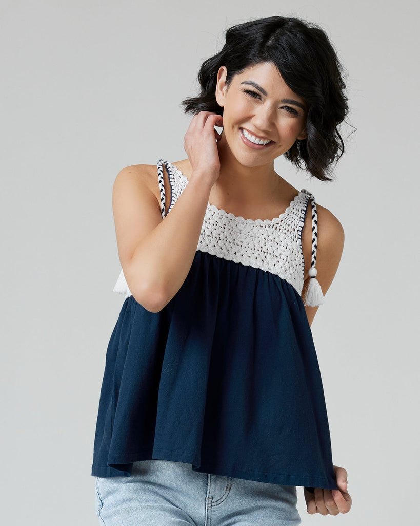 Woman in a navy tank top with crocheted fabric at top