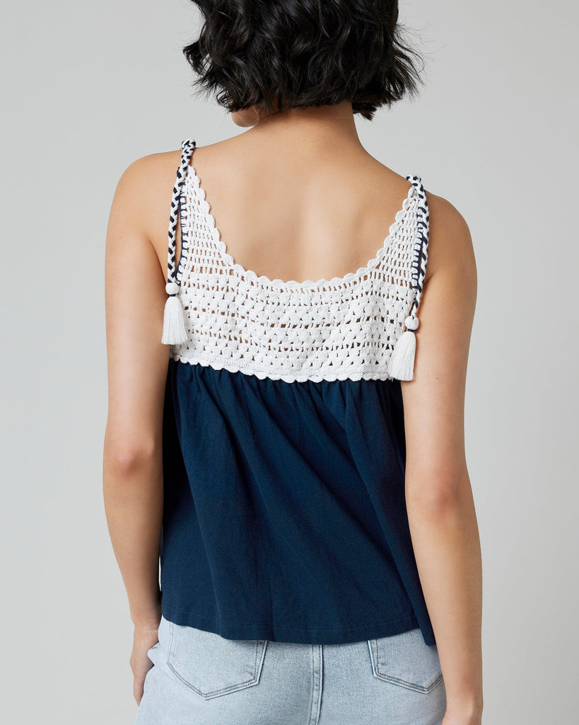 Woman in a navy tank top with crocheted fabric at top