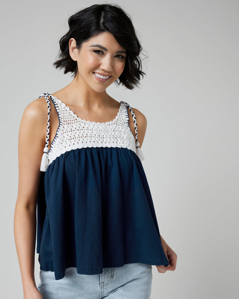 Woman in a navy tank top with crocheted fabric at top