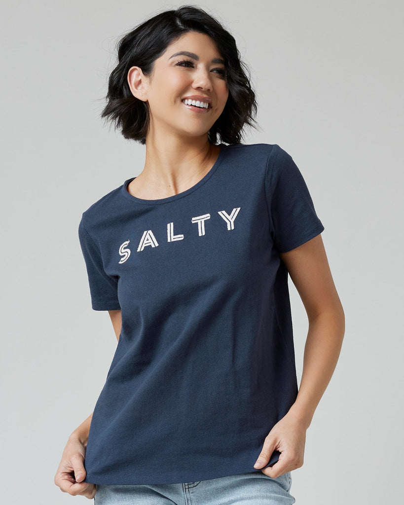 Woman in a navy graphic t-shirt with "SALTY" across the front