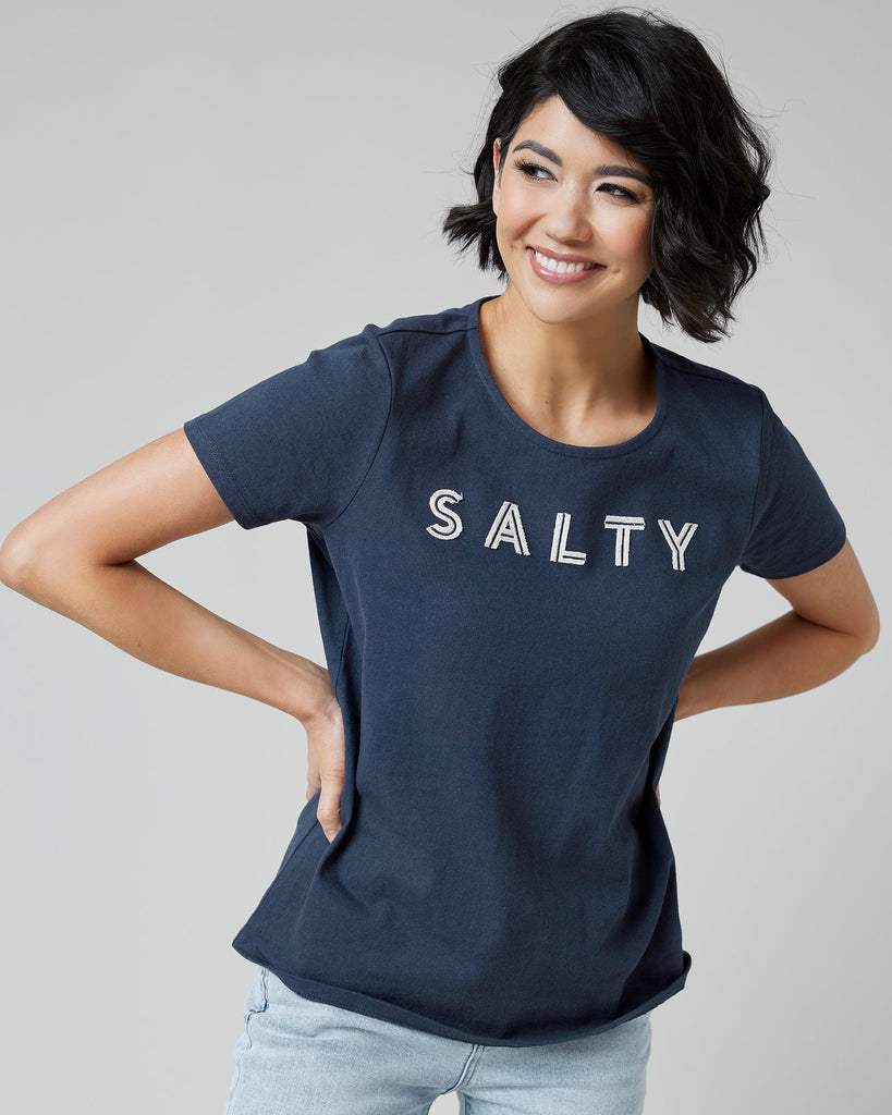 Woman in a navy graphic t-shirt with "SALTY" across the front