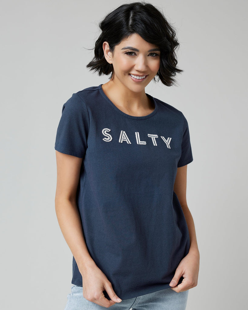 Woman in a navy graphic t-shirt with "SALTY" across the front